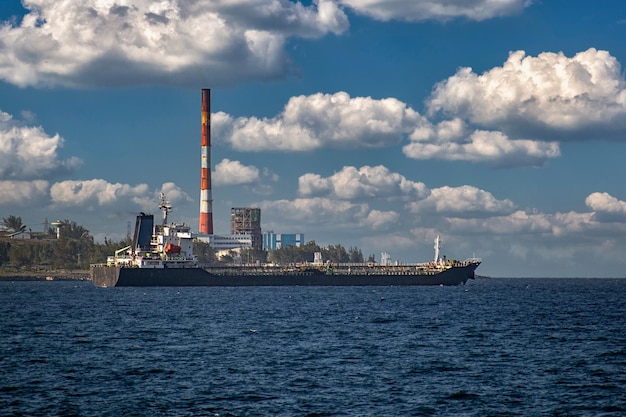 Navire quittant la baie de Matanzas à Cuba avec la centrale thermoélectrique en arrière-plan