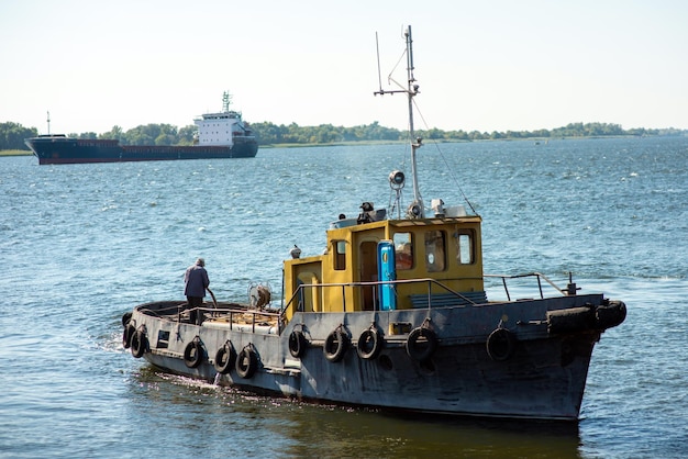 Navire remorqueur dans la rivière sur le fond d'un cargo