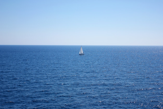 Navire solitaire dans le paysage marin bleu