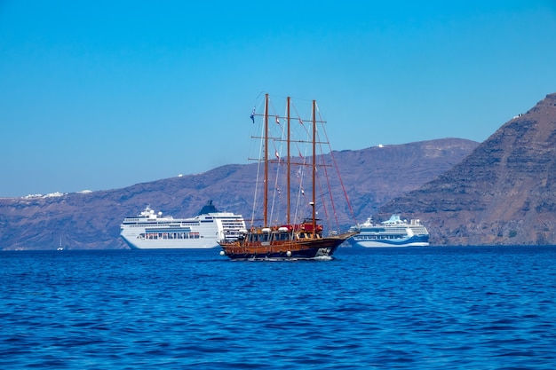 Navires de croisière modernes et vieux voilier au large de Santorin