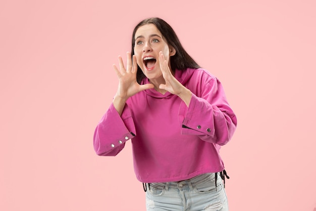 Ne manquez pas. Jeune femme décontractée criant. Crier. Femme émotionnelle qui pleure criant sur le mur rose. Portrait de femme en demi-longueur. Émotions humaines, concept d'expression faciale. Couleurs tendance