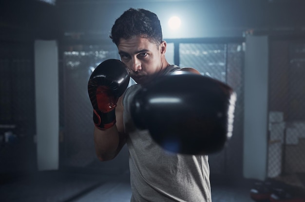 Ne plaisante pas avec mes muscles Portrait d'un jeune homme pratiquant sa routine de boxe dans une salle de sport