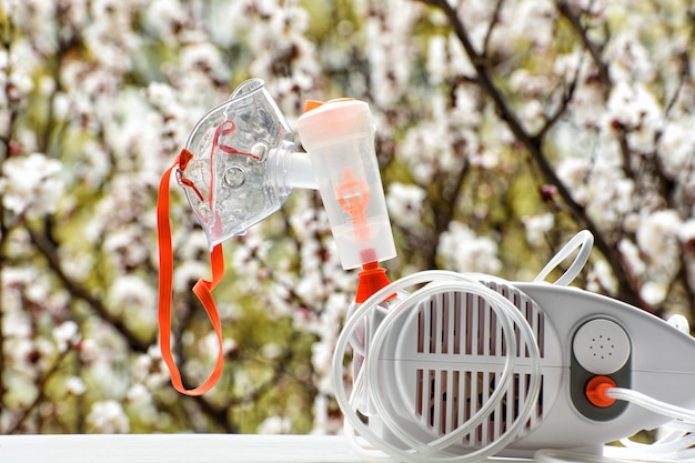 Nébuliseur avec un masque sur un arbre en fleurs.