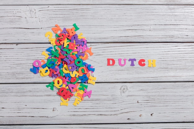 Le néerlandais de mots colorés faits avec des lettres colorées sur planche de bois blanc