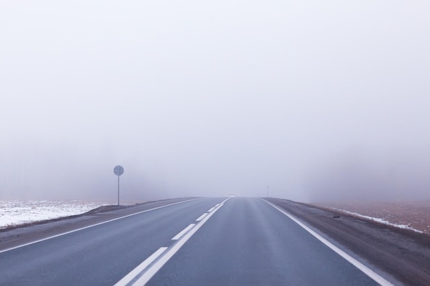 neige abstraite de brouillard de route d'hiver, vue de paysage dans le transport de novembre