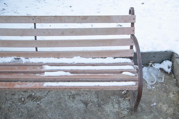 Neige sur un banc au parc d'hiver