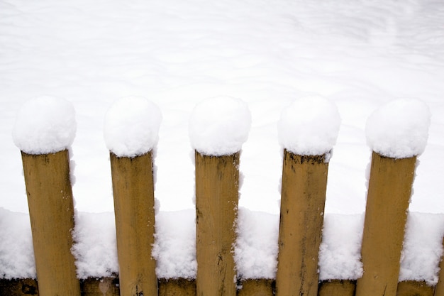 Neige sur une clôture en bois. Clôture en bois rustique recouverte de neige