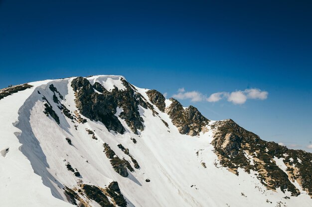 Neige dans les montagnes et printemps de ciel bleu