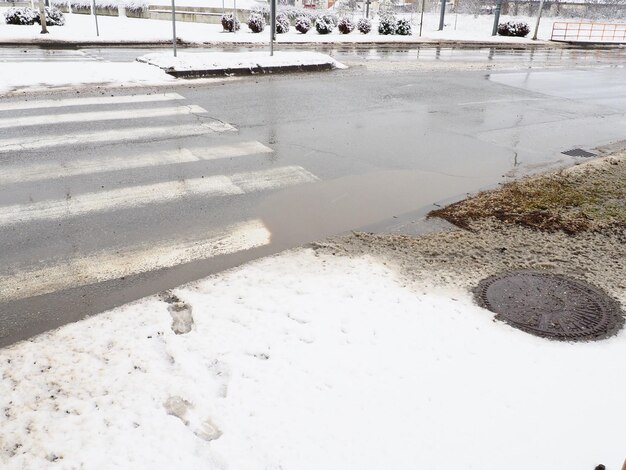 Neige Fondante Et Boue Hivernale à Un Passage Pour Piétons La Température  De L'air Est D'environ 0 Conditions De Conduite Difficiles Distance De  Freinage De La Voiture Drain Souterrain Avec Grille Métallique