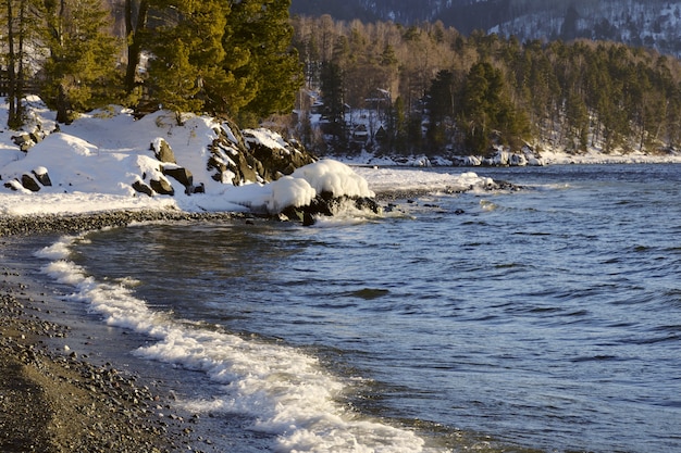 neige et glace sur les rochers au bord du lac teletskoïe qui ne gèle pas en hiver