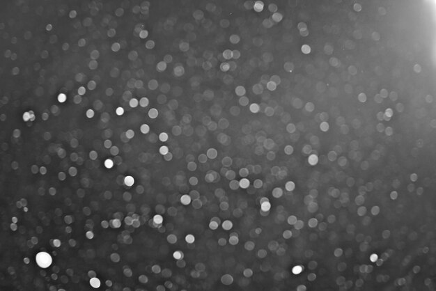 Neige sur une superposition de texture de fond noir met en évidence le bokeh