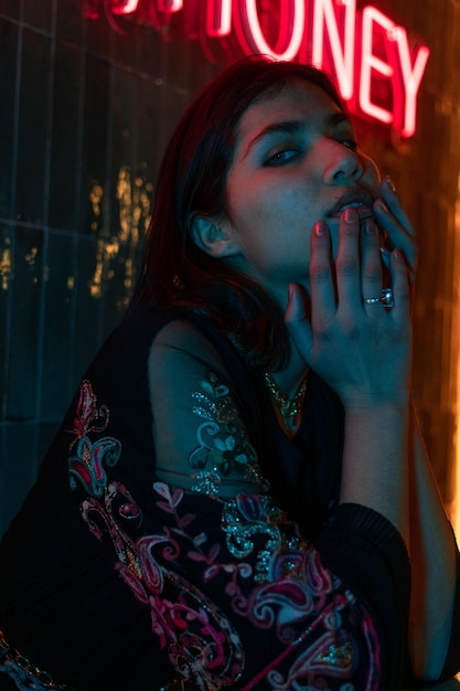 Neon close up portrait of young woman wear hoodie. photo de rue de la ville de nuit