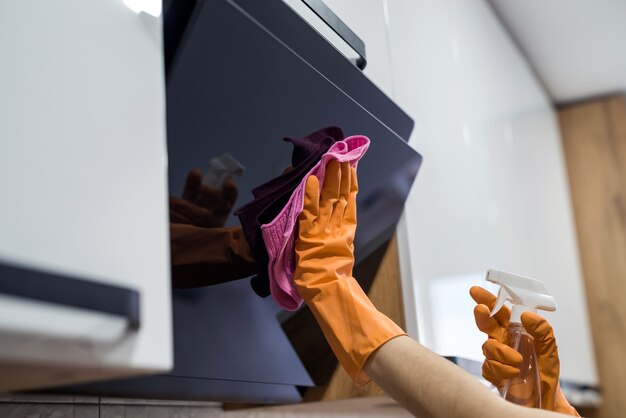 Nettoyage de la cuisine. Hotte de cuisine femme lavage des mains avec éponge. Travaux ménagers