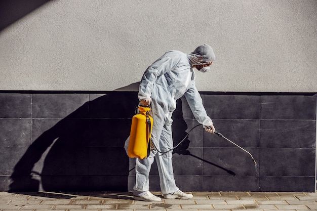 Nettoyage et désinfection à l'extérieur autour des bâtiments, l'épidémie de covid-19. équipes de session pour les efforts de désinfection. Prévention des infections et contrôle de l'épidémie. costume et masque.