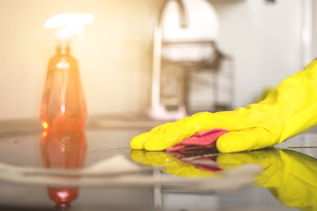 Nettoyage avec un détergent en aérosol, des gants en caoutchouc et un torchon sur la surface de travail, photo d'arrière-plan de la cuisine