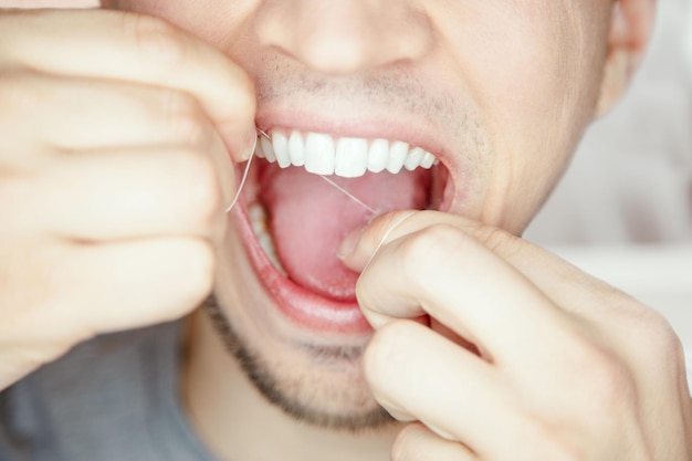 Nettoyage des mains des hommes et délogement des aliments coincés entre les dents