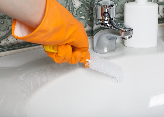 Nettoyage de la salle de bain avec des gants en caoutchouc. Fermer
