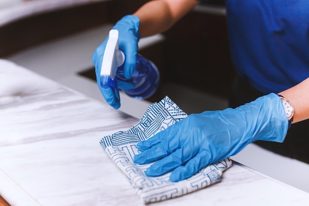 Nettoyage de la table à la maison désinfection de la surface de la table de cuisine avec désinfectant lavage de bouteilles de pulvérisation