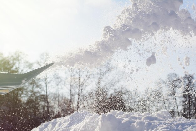 Nettoyage des trottoirs après un violent blizzard de neige avec une pelle dans une journée ensoleillée et glaciale