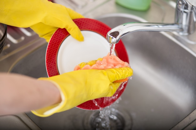 Nettoyage vaisselle vaisselle évier éponge lave vaisselle. Fin, haut, femme, mains, jaune, protecteur, caoutchouc, gants, lavage