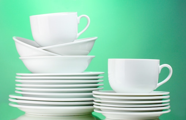 Nettoyer les assiettes, les tasses sur une surface verte