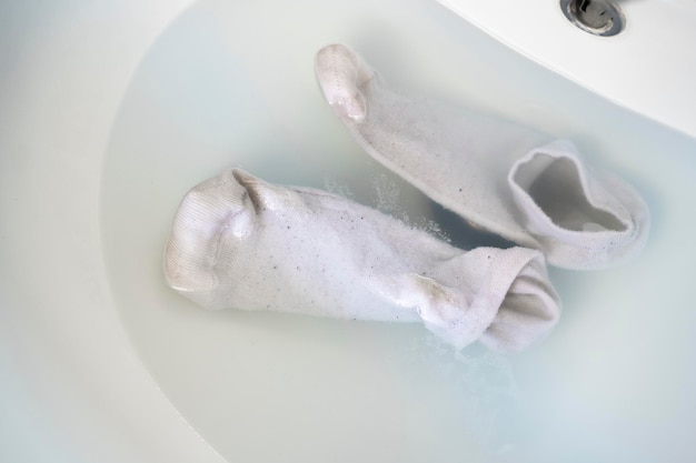 Nettoyer les chaussettes sales dans l'eau du lavabo