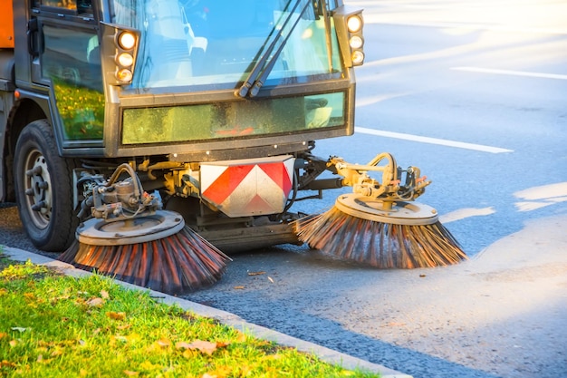 Photo nettoyer les feuilles avec une brosse de route en automne