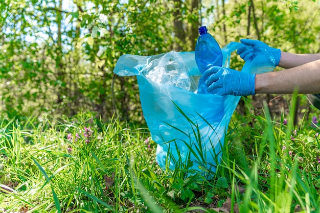 Nettoyer la nature en collectant les déchets plastiques, les bouteilles en plastique de la boisson provoquent une catastrophe écologique