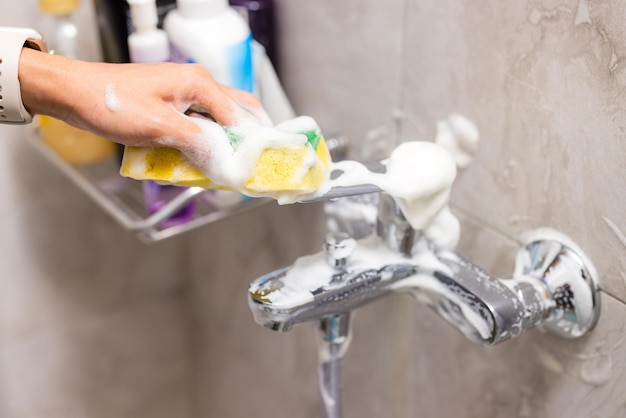 Nettoyer les taches d'eau dure déposées sur le robinet de la baignoire aux toilettes