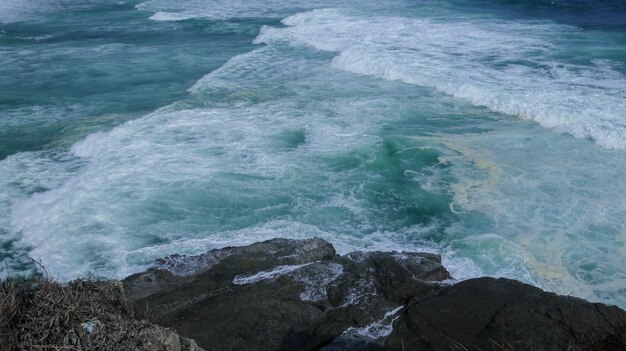 Photo nettoyer les vagues et les rochers de la plage
