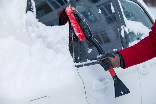 Nettoyer la voiture de la neige après la saison hivernale du blizzard