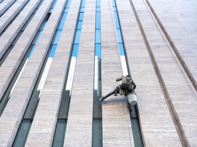 Le nettoyeur de vitres travaille sur l'immeuble de bureaux