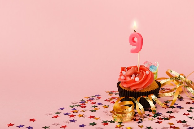 Photo neuvième cupcake d'anniversaire avec bougie et paillettes
