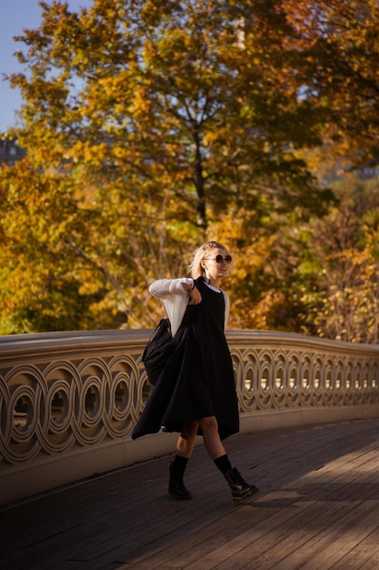 New York Manhattan Central Park en automne, pont sur le lac. jeune femme se promène dans un parc d'automne à New York.