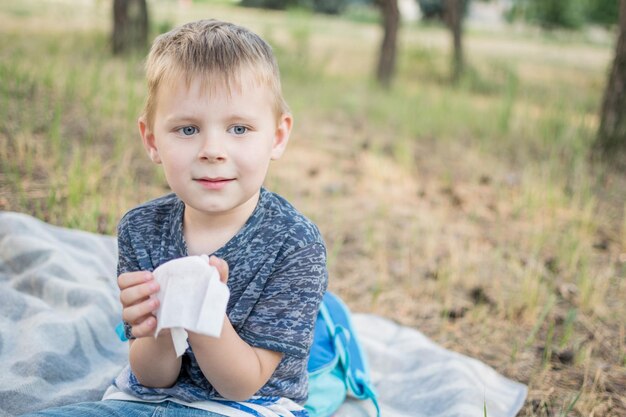 Nez qui coule avec un petit garçon Un enfant avec un mouchoir près du nez