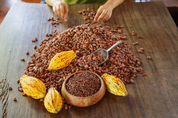 Nibs de cacao et fruits de cacao sur table en bois