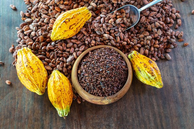 Nibs de cacao et fruits de cacao sur table en bois