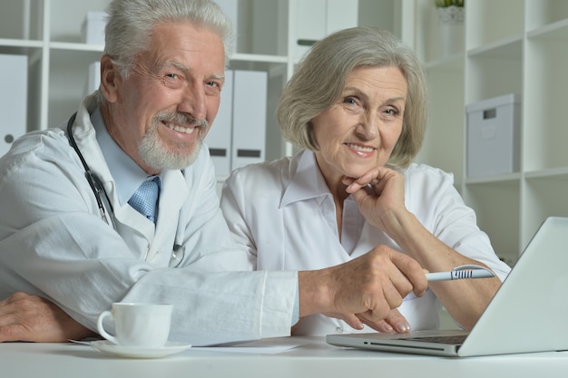 Nice senior Doctors with laptop in office