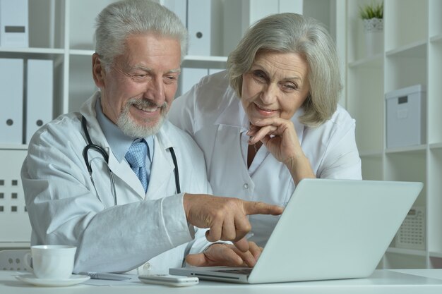 Nice senior Doctors with laptop in office