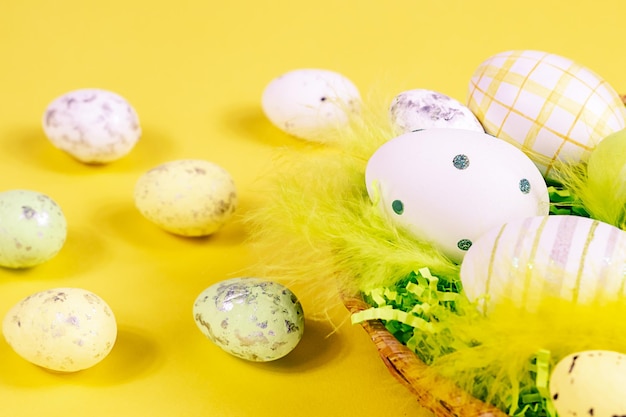 Nid de Pâques avec des oeufs et des plumes sur un fond jaune libre Concept minimal