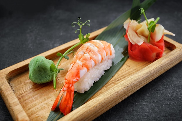 Nigiri Ebi sur planche de bois avec wasabi et gingembre