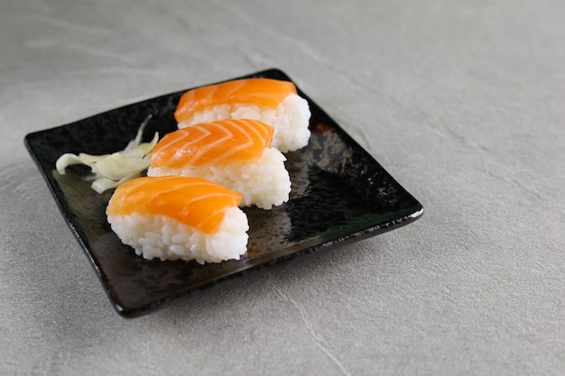 Photo nigiri sushi au saumon frais servi sur une assiette en céramique