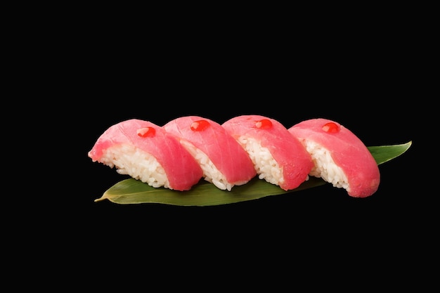 Nigiri sushi thon avec sauce sriracha ciboulette feuille de bananier cuisine japonaise sur fond noir isolé menu japonais