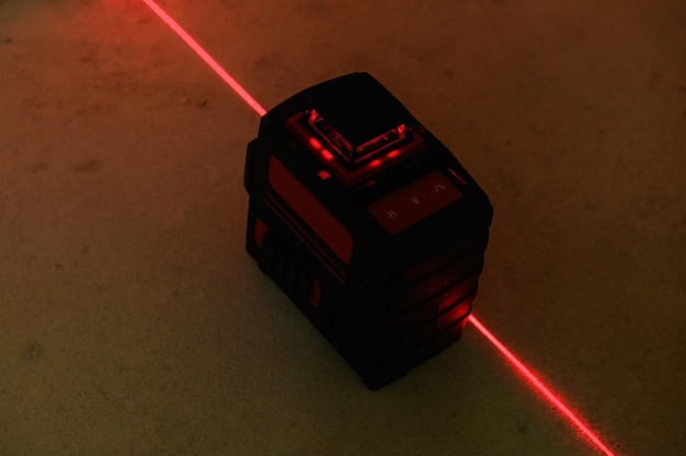 Niveau laser rouge allumé dans une pièce sombre