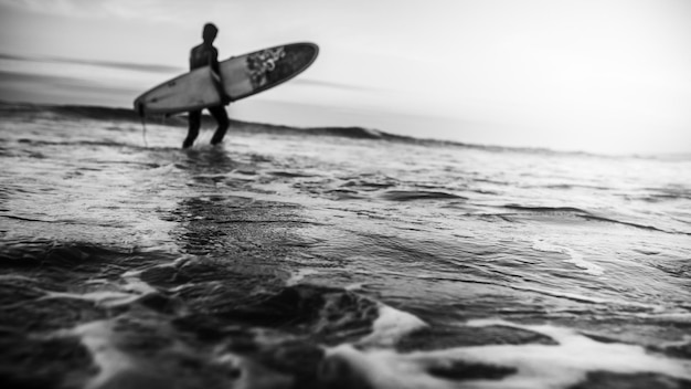 Photo niveau de surface du surfeur debout dans la mer contre le ciel