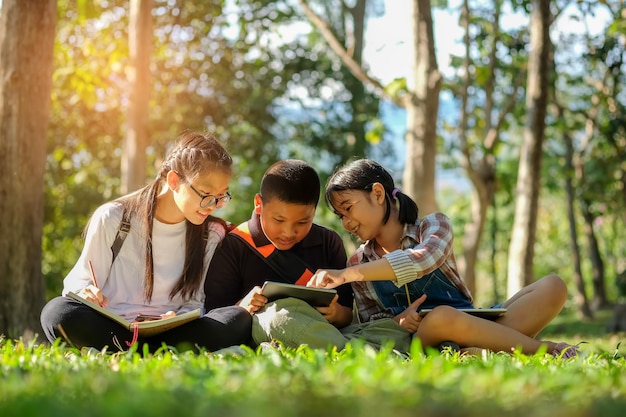 Niveau de surface des enfants discutant sur une tablette numérique dans le parc