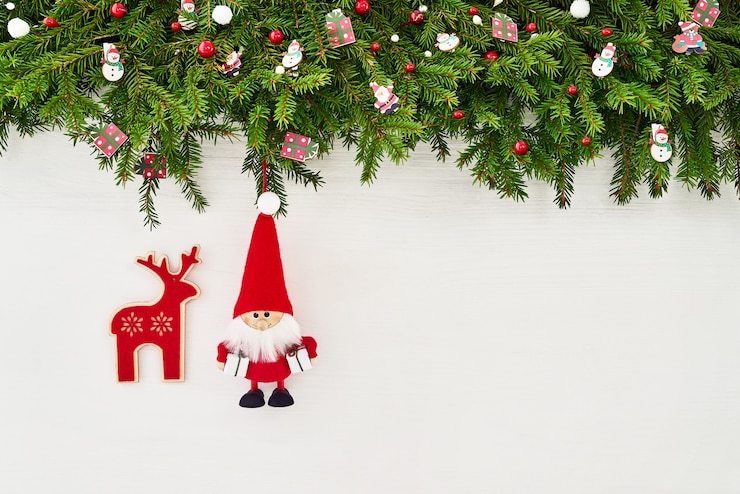 Photo noël . branche de sapin de noël avec père noël et chaussettes de noël sur un fond en bois blanc. fond, vue de dessus