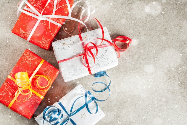 Noël avec des cadeaux décorés. Gris, effet de neige, fond de vue de dessus