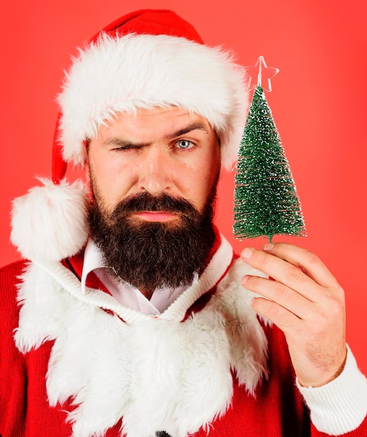 Noël et célébration du Nouvel An homme barbu sérieux en costume de Père Noël avec petit arbre de Noël