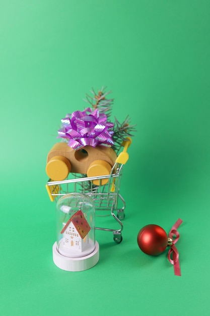 Noël, un chariot de jouet d'un supermarché avec une petite voiture et une petite maison avec éclairage